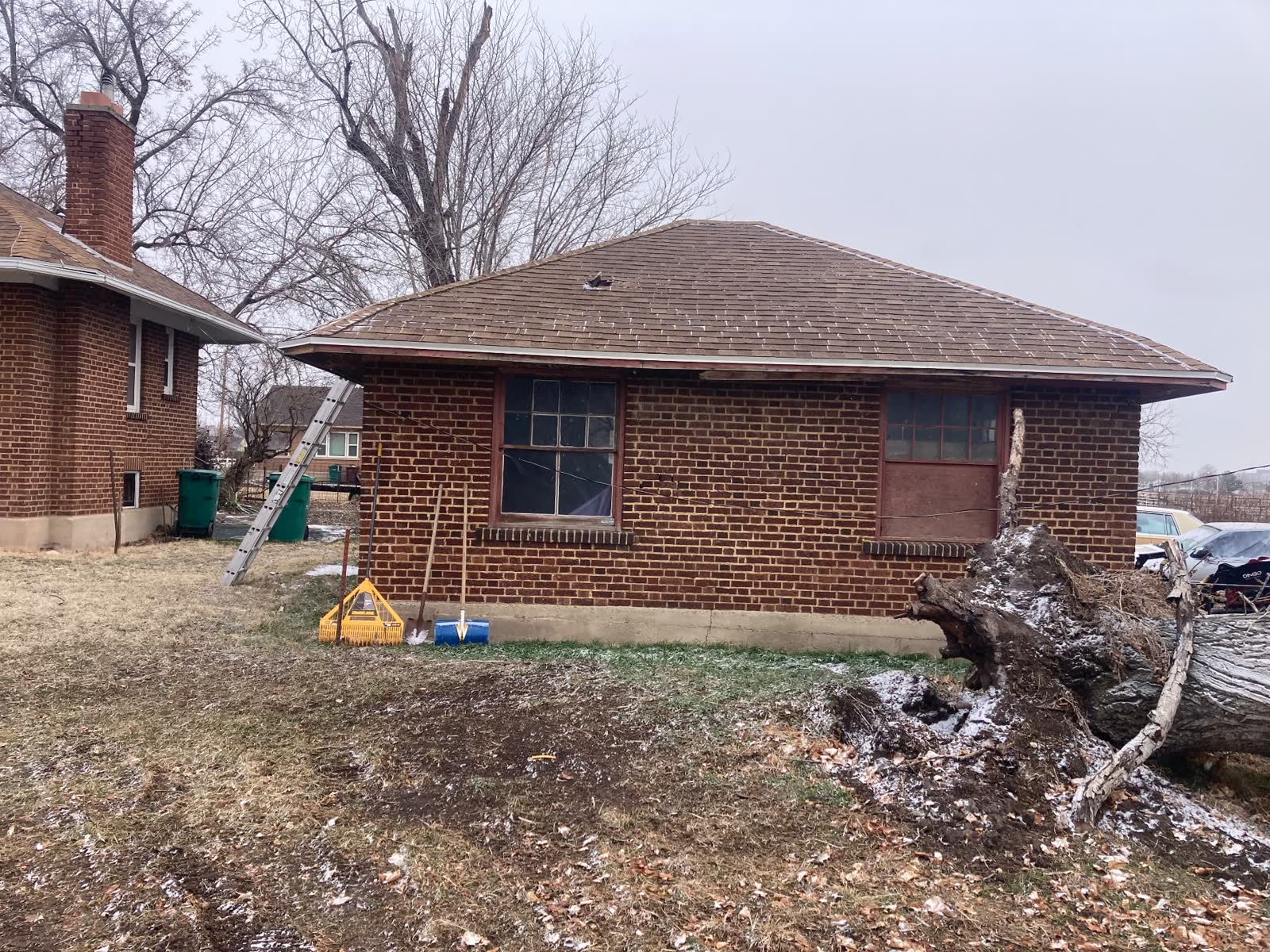 Brick house with the uprooted hazard tree removed and the yard cleared